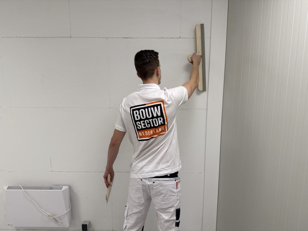 Stukadoor van Bouwsector Nederland met spaan bij een wand